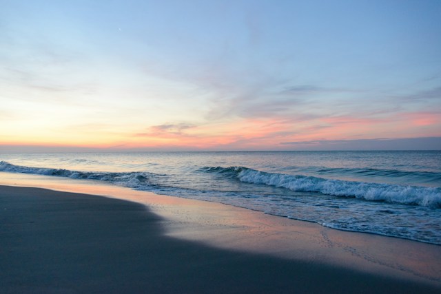 Gentle waves rolling onto shore at sunset